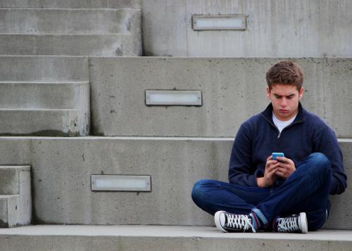 boy texting on phone sitting