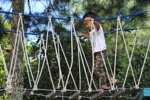 child crossing rope bridge