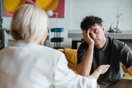 woman talking to boy with head in hands